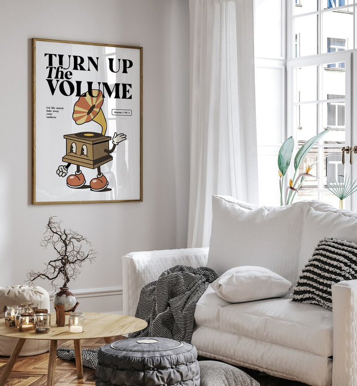 Turn Up the Volume Quotes and Typography Posters in Oak Wood Plain Frame placed on a wall in the living room beside a white sofa and a window