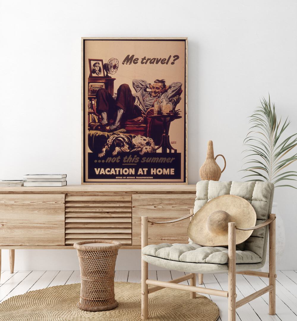 Vacation at Home  Retro Travel Posters in Oak Wood Plain Frame placed on a console table behind a chair