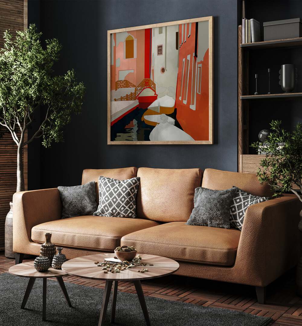 Venedig II By Ana Rut Bre Landscape Art Prints in Oak Wood Plain Frame placed on a Dark Grey Colored Wall near a Brown Sofa in the Living Room