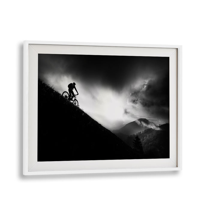 Silhouette of a cyclist on a mountain at dawn, featured in SUNRISE RIDE, PHOTOGRAPHY PRINTS collection.