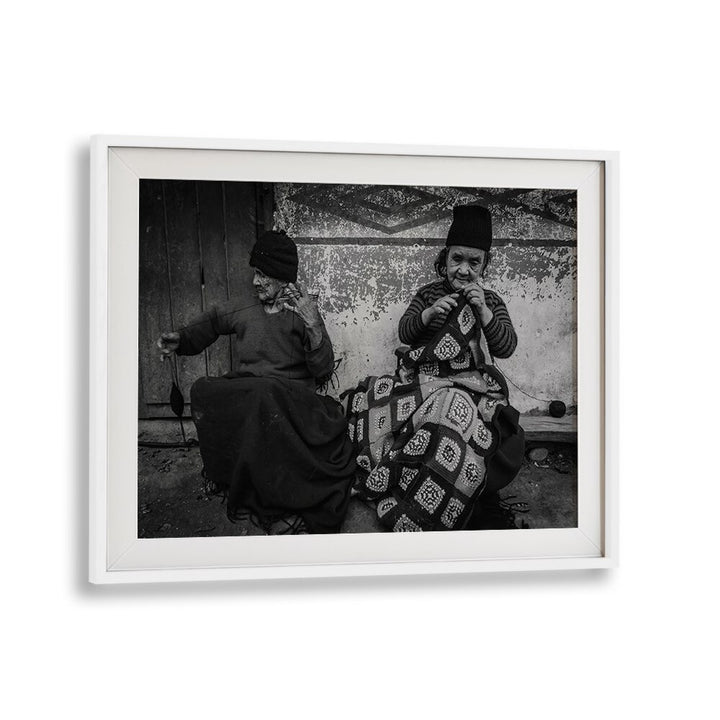 Two elderly women knitting together in a warm moment, featured in KNITTING SISTERS, PHOTOGRAPHY PRINTS collection.