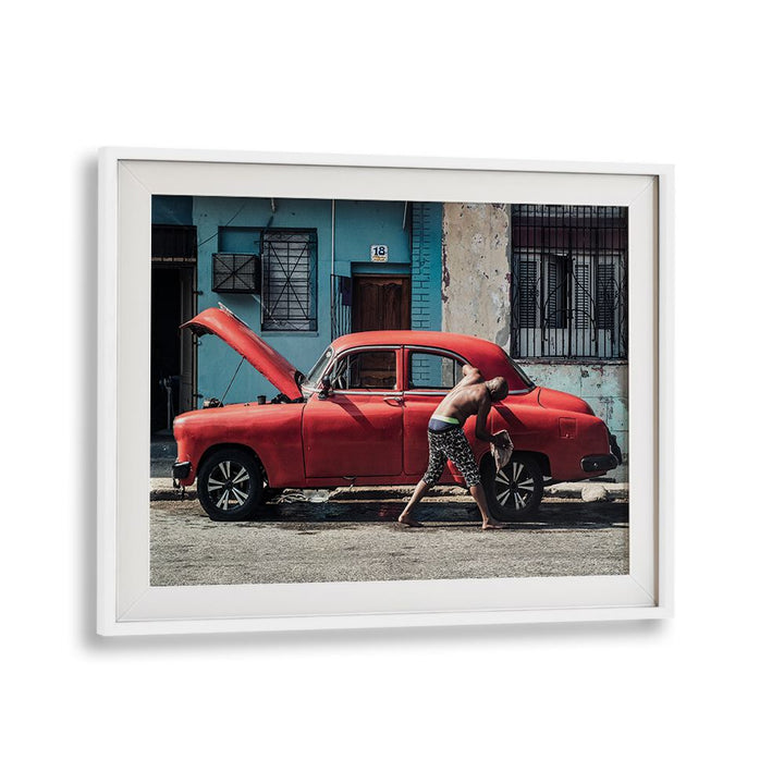 A man washing a vintage red car on the street, perfect for WASHING A CAR, PHOTOGRAPHY PRINTS collection.