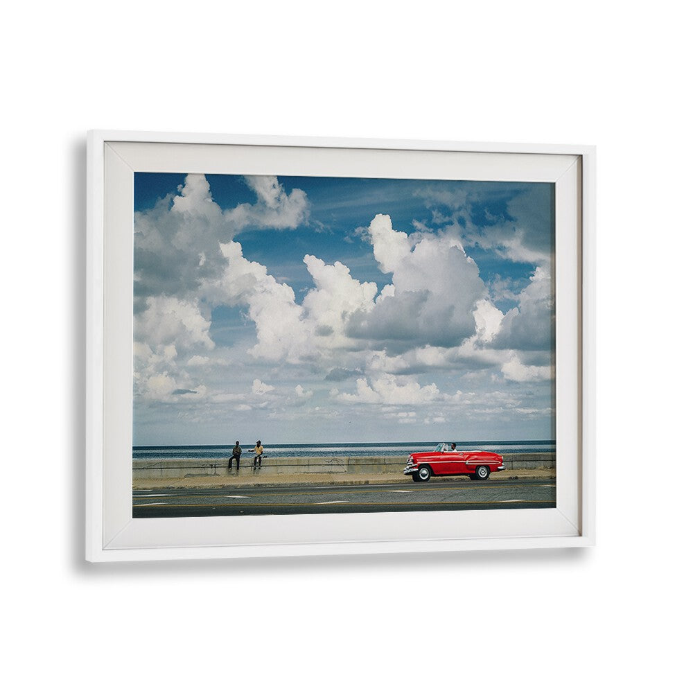 Capturing urban life, MALECON VIII, PHOTOGRAPHY PRINTS features a vibrant scene with a classic car and dynamic clouds.