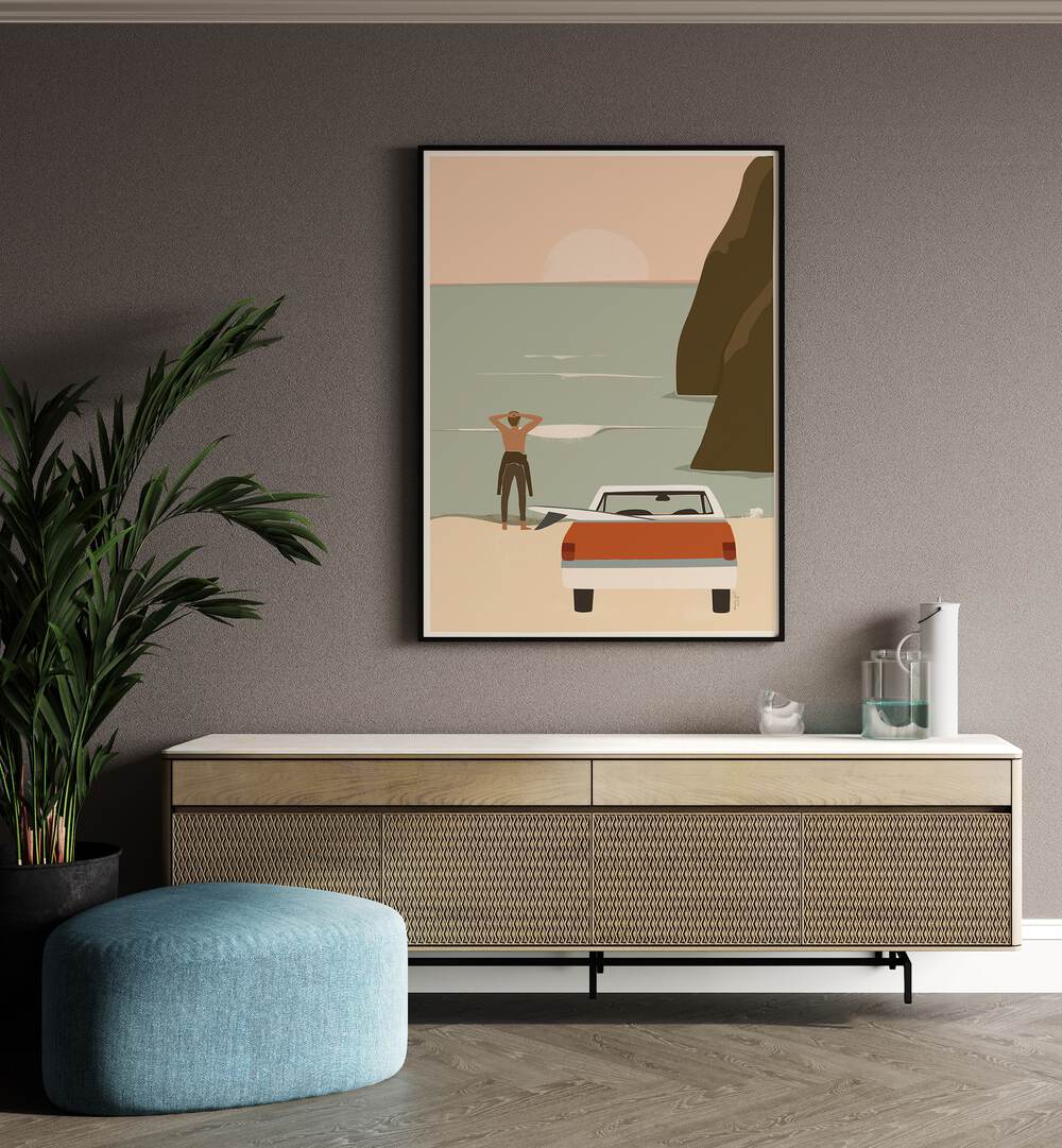 Waiting For The Wave By Andi Bell Beach Prints in Black Plain Frame on a beige wall placed above a console table beside a plant