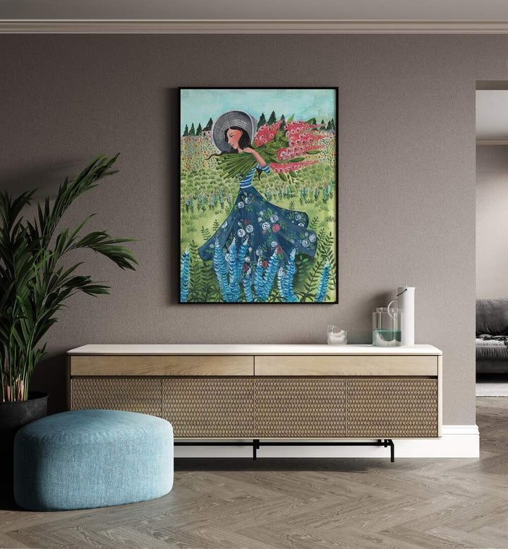 Walking With Field Flowers By Caroline Bonne Muller Women Paintings in Black Plain Frame on a beige wall above a console table beside a plant