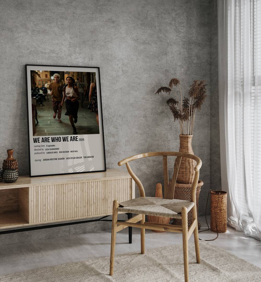 We Are Who We Are 2020 Movie Posters in Black Plain Frame placed on a console table behind  a chair