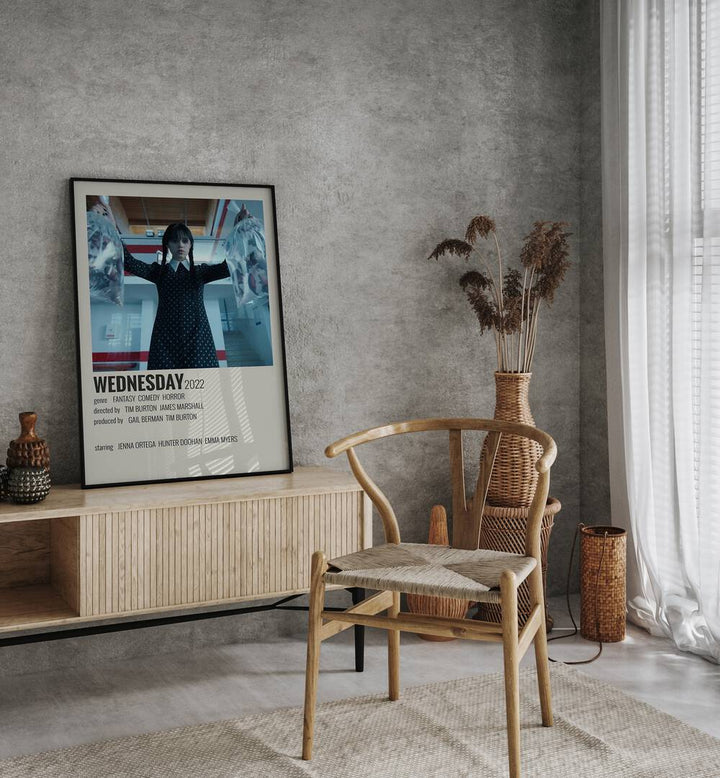 Wednesday 2022 Movie Posters in Black Plain Frame placed on a console table behind a chair