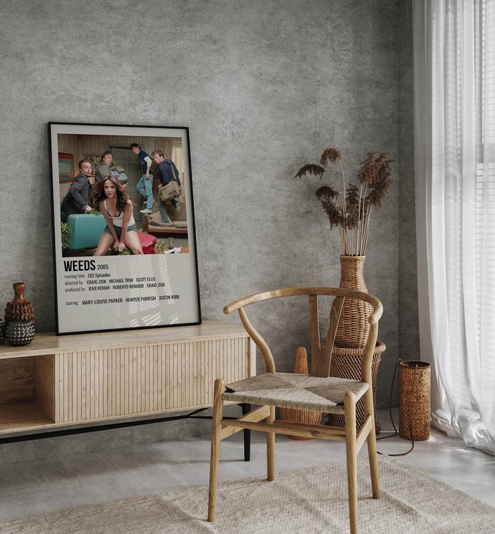 Weeds 2005 Movie Posters in Black Plain Frame placed on a console table behind a chair