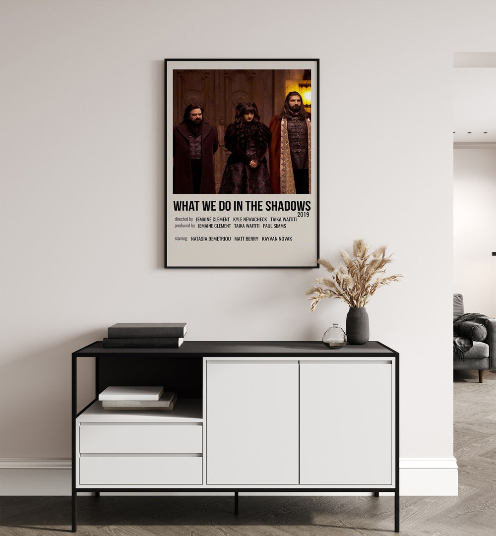 What We Do In The Shadows 2019 Movie Posters in Black Plain Frame placed on a white wall behind a table