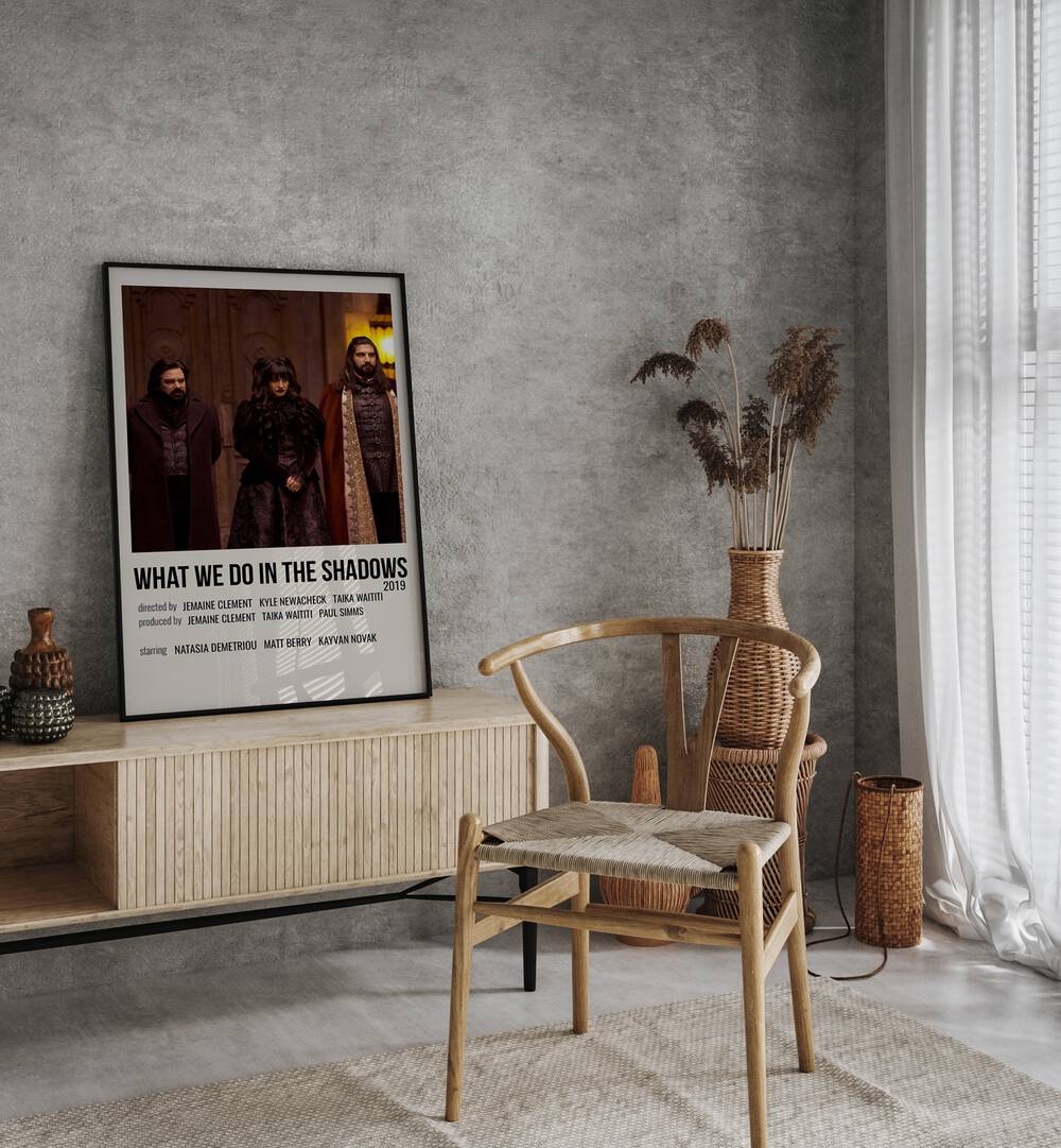 What We Do In The Shadows 2019 Movie Posters in Black Plain Frame placed on a console table beside a chair