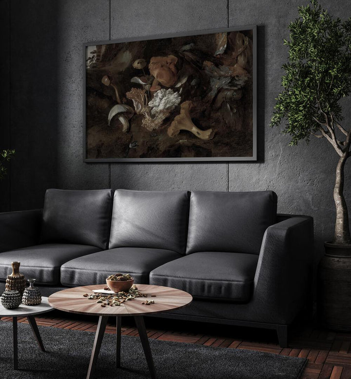 Whimsical Whispers Dancing Mushrooms In The Forest Glade Gothic Art Prints in Black Plain Frame hanging on a wall above black leather couch beside a plant.