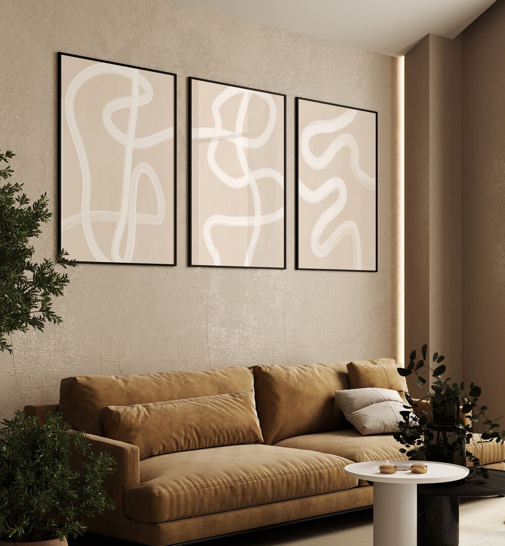 White Brush Strokes Set Of 3 Paintings in Black Plain Frame placed on a beige wall behind a brown sofa for living room