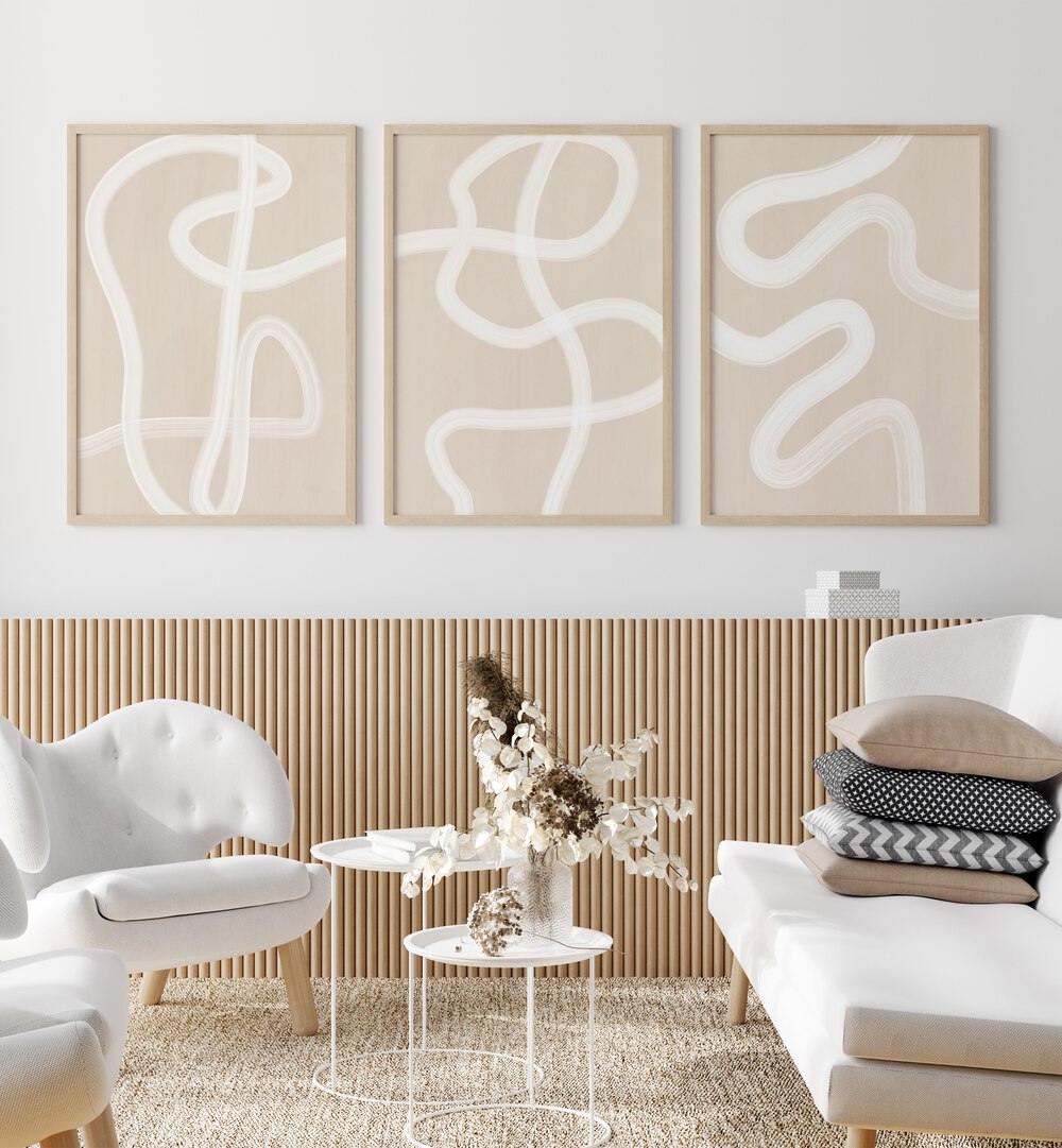 White Brush Strokes Set Of 3 Paintings in Oak Wood Plain Frame placed on a white wall beside a white sofa and chairs