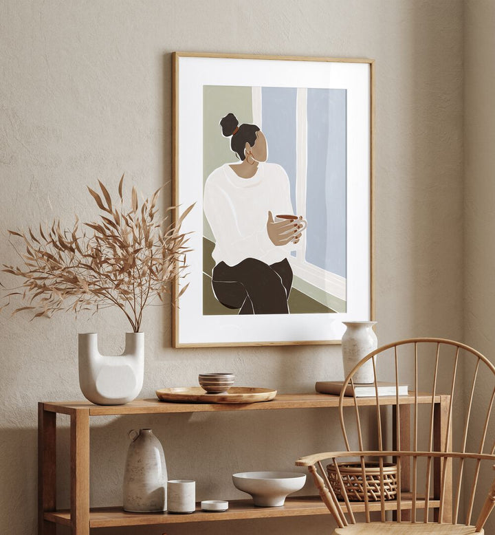 Woman Enjoying a Cup of Tea By Ivy Green Women Illustration Paintings in Oak Wood Frame With Mount on a beige wall above a table