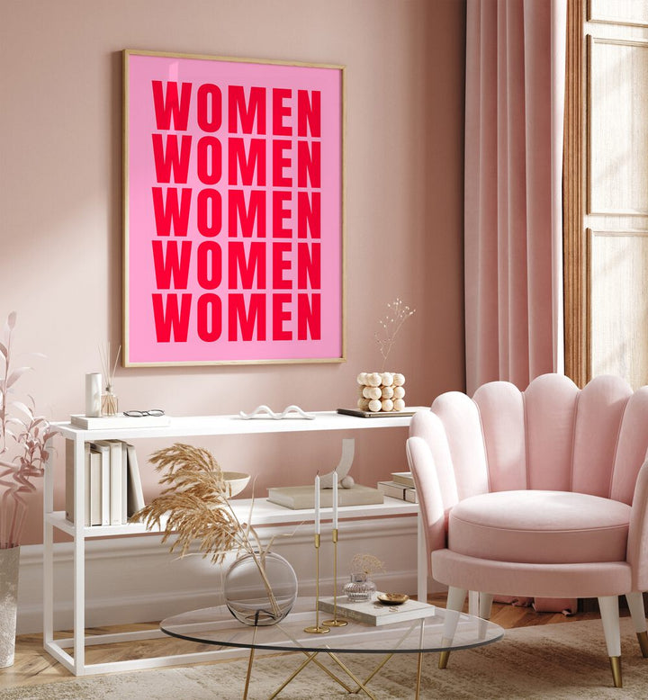 Women women by Athene Fritsch Quotes and Typography Posters in Oak Wood Plain Frame placed on a pink wall beside a window and behind a table