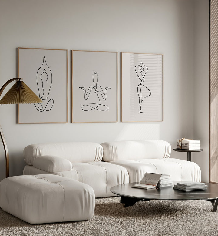 Yoga Line Art Set Set Of 3 Paintings in Oak Wood Plain Frame placed on a white wall behind a white sofa for living room