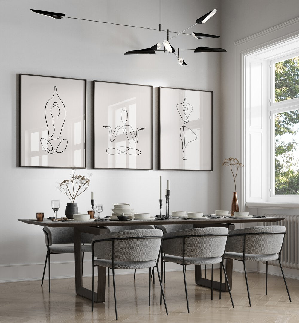 Yoga Line Art Set Set Of 3 Paintings in Black Plain Frame placed on a dining room wall behind a dining table and beside a window