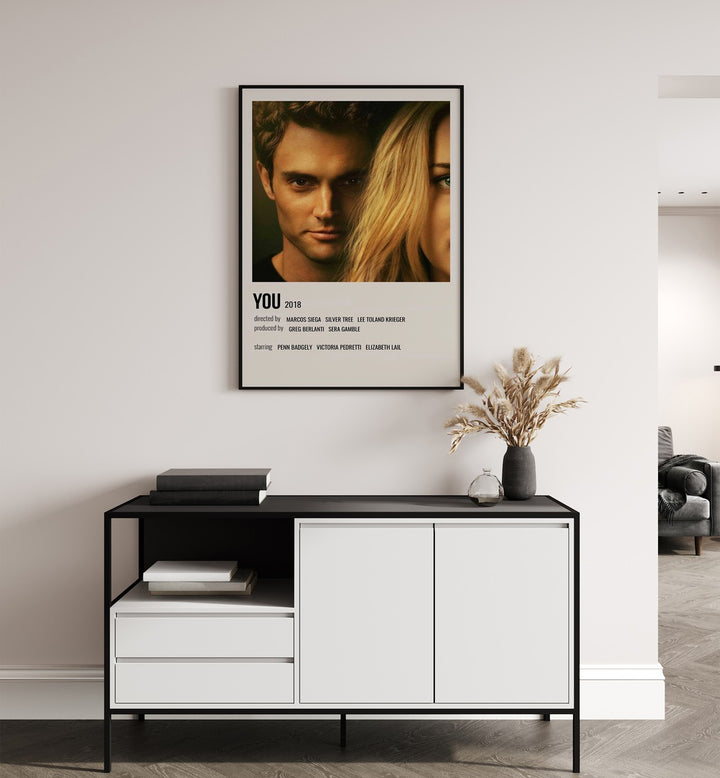 You 2018 Movie Posters in Black Plain Frame placed on a wall behind a black and white table 