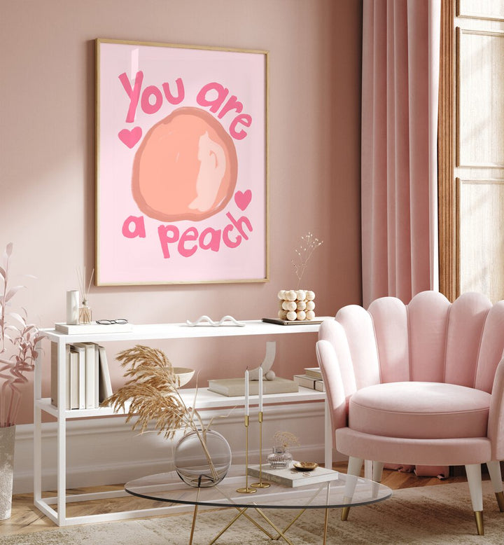 You Are a Peach by Athene Fritsch Quotes and Typography Posters in Oak Wood Plain Frame placed on a pink wall beside a window and behind a table