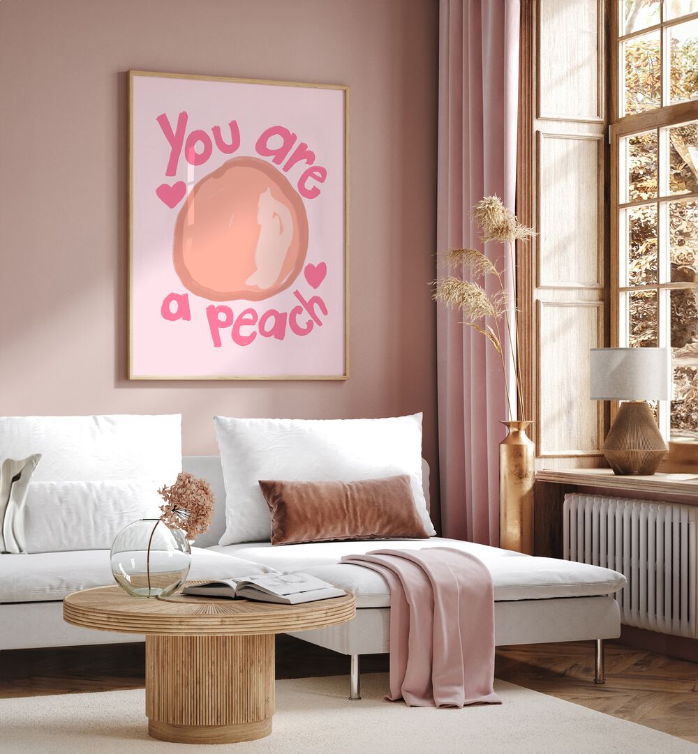 You Are a Peach by Athene Fritsch Quotes and Typography Posters in Oak Wood Plain Frame placed on a living room wall behind a sofa and beside a window