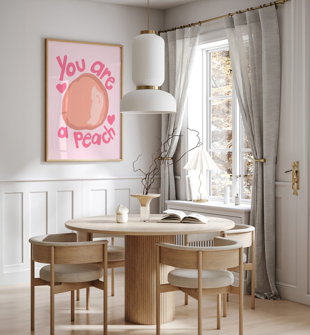 You Are a Peach by Athene Fritsch Quotes and Typography Posters in Oak Wood Plain Frame placed on a wall in a dining room area beside a window and behind a dining table