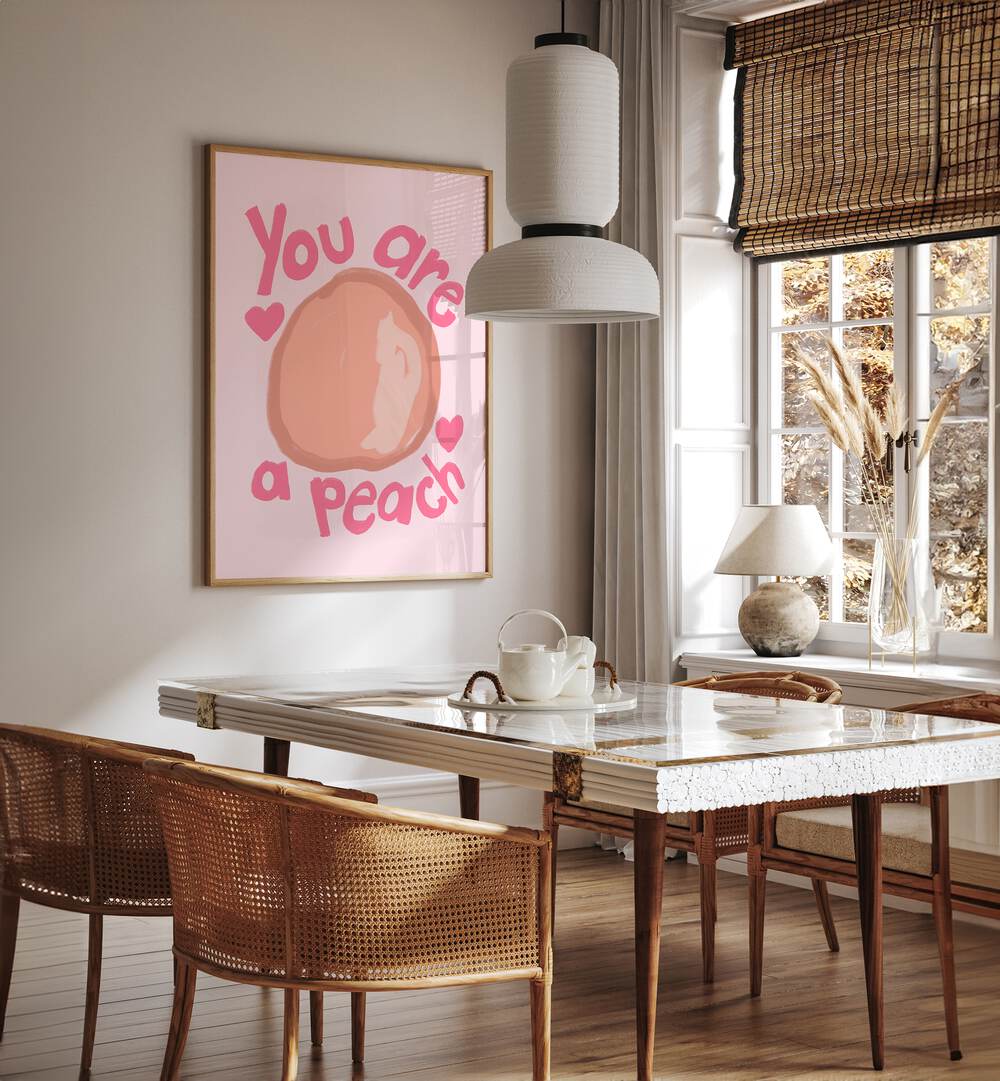 You Are a Peach by Athene Fritsch Quotes and Typography Posters in Oak Wood Plain Frame placed on a wall in a dining room area beside a window and behind a dining table