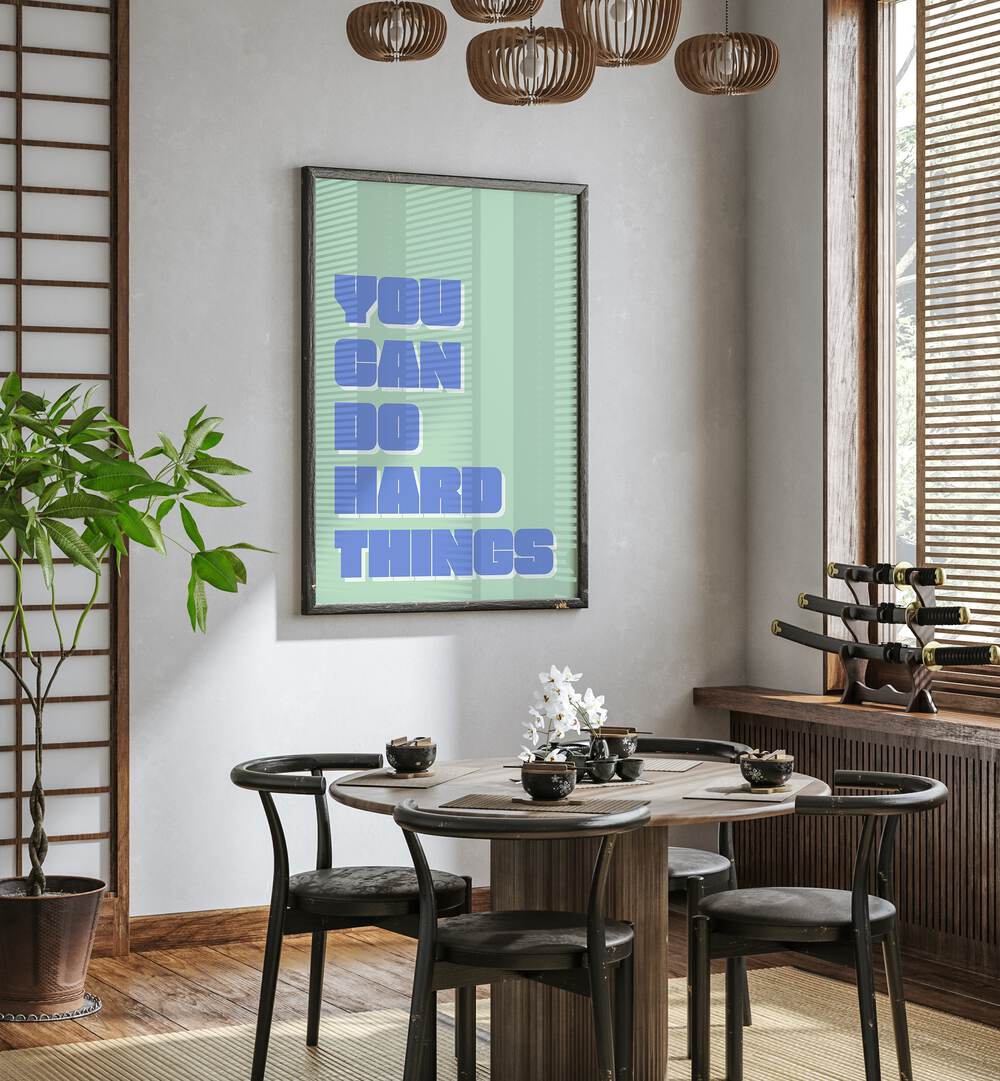 You Can Do Hard Things by Athene Fritsch Quotes and Typography Posters in Black Plain Frame placed on a wall in a dining room area beside a window and behind a dining table