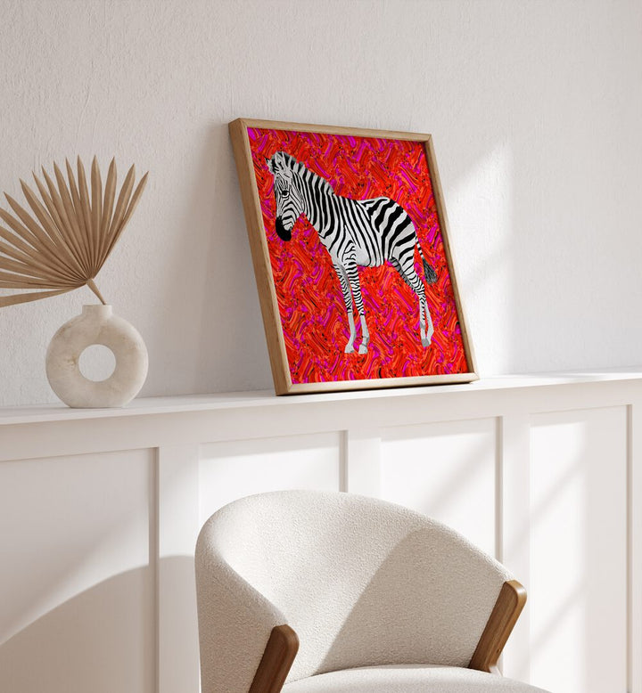 Zebra By Lynnda Rakos Pop Art Paintings Pop Art Prints in Oak Wood Plain Frame placed on a shelf behind a chair