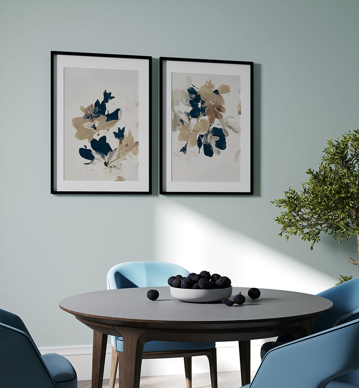 Dining room with floral framed art on the wall, a round table with a bowl of fruit, and blue chairs.