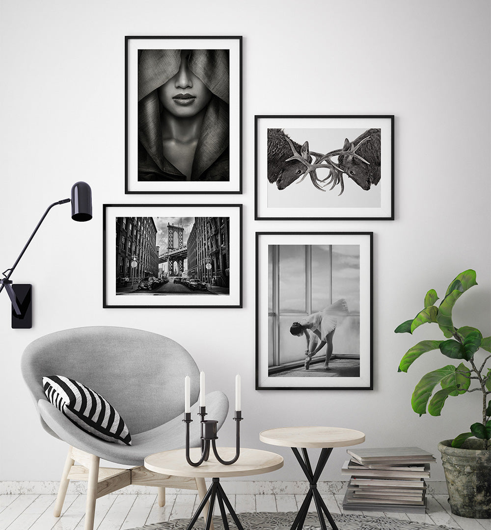 Modern interior with black and white framed art on a wall, a gray armchair, and decorative elements.